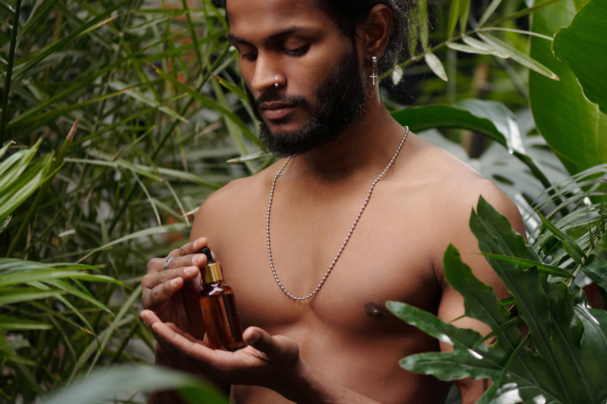 A man holds our all natural, nourishing, handmade beard oil to keep your beard soft while moisturizing the skin underneath. 